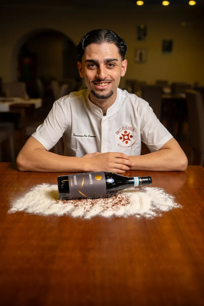 Francesco al tavolo con la bottiglia di vino Origini